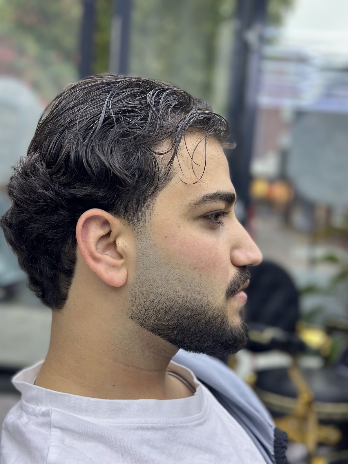 Zijaanzicht van een knipbeurt met volle baard bij Naji Barbershop