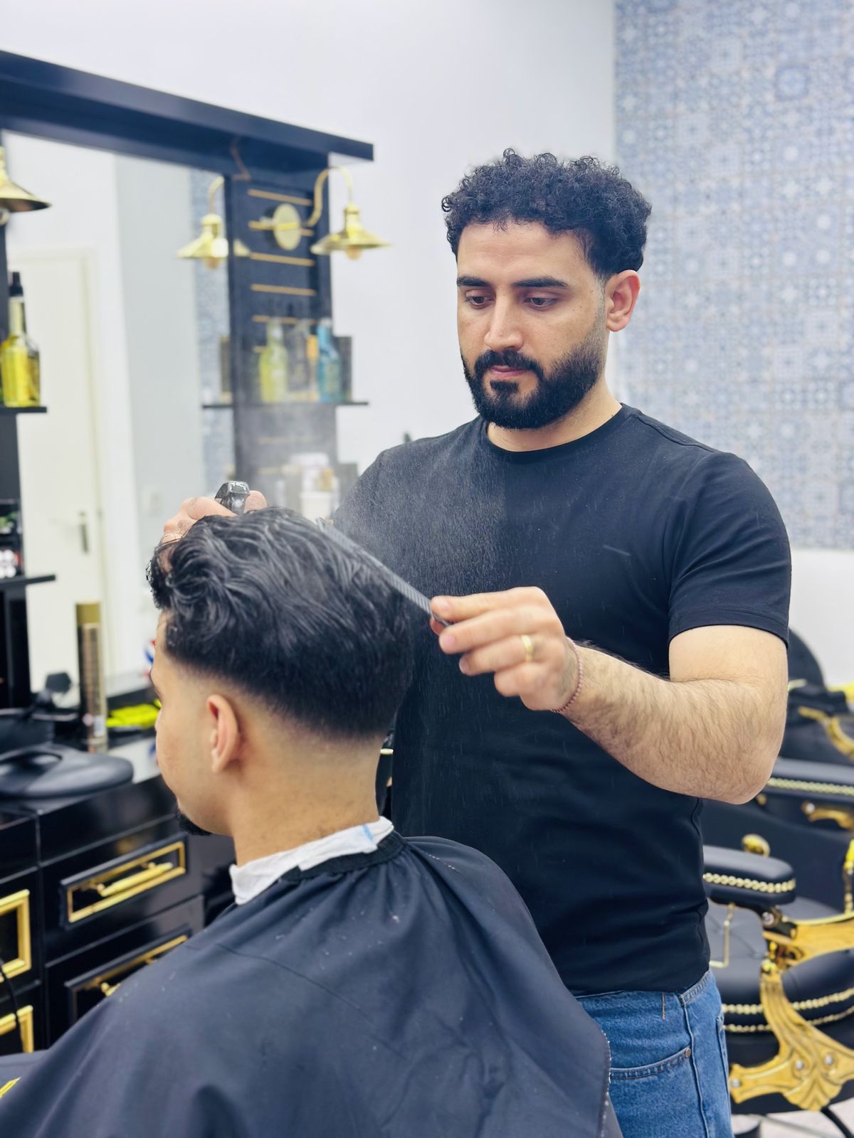 De barbier aan het werk: haar natspuiten en in model kammen bij Naji Barbershop